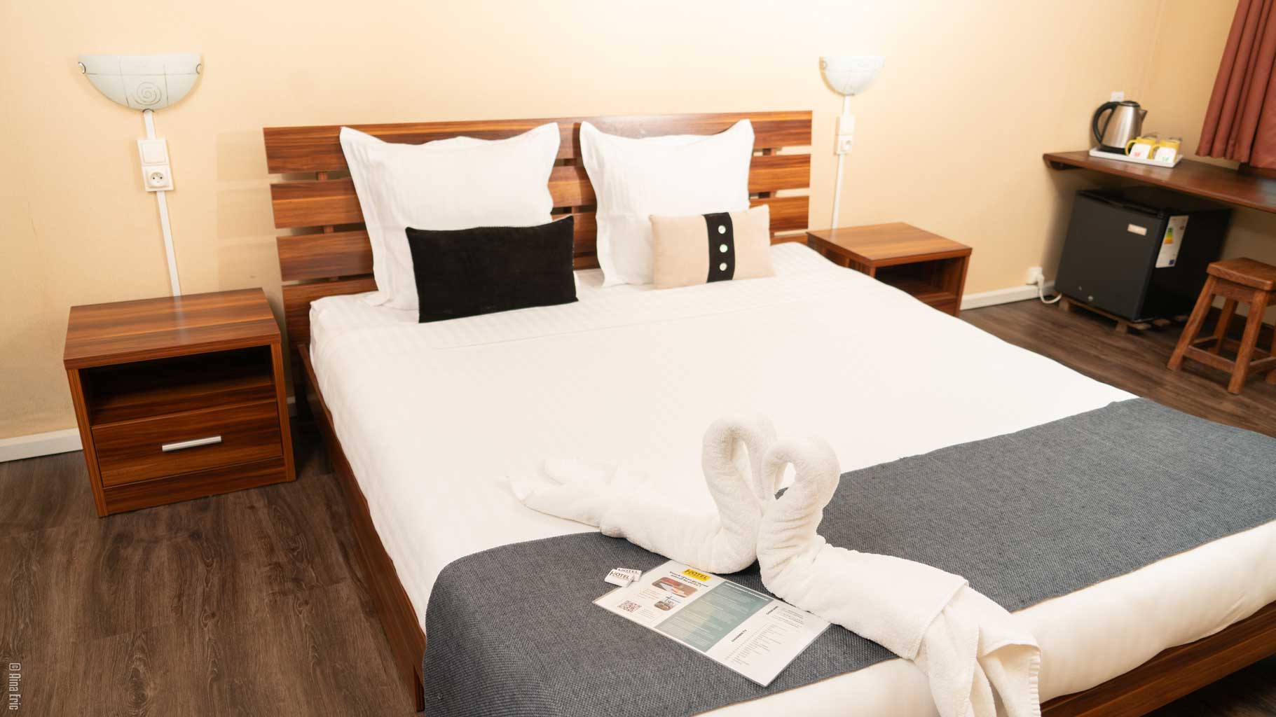 Lit blanc avec jeté gris - Hôtel Le Pousse Pousse Antaninarenina